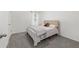 Bedroom featuring neutral colors, carpet flooring, one window, and a bed with a tan headboard at 11205 Se 69Th Ter, Belleview, FL 34420