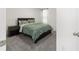 Cozy bedroom featuring carpet floors, a window, and a bed with a dark headboard and green patterned comforter at 11205 Se 69Th Ter, Belleview, FL 34420