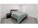 Cozy bedroom featuring carpet floors, a window, and a bed with a dark headboard and green patterned comforter at 11205 Se 69Th Ter, Belleview, FL 34420