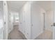 Bright hallway with multiple doors, carpet in one section, and tile in another section at 11205 Se 69Th Ter, Belleview, FL 34420