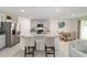 Open kitchen features a large granite island, stainless appliances, and a dining area at 11205 Se 69Th Ter, Belleview, FL 34420