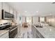 Modern kitchen with a breakfast nook leading into a living room with stainless steel appliances and granite countertops at 11205 Se 69Th Ter, Belleview, FL 34420