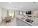 Bright, open-concept living room with a breakfast nook leading into a living room with a large TV at 11205 Se 69Th Ter, Belleview, FL 34420
