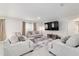Spacious living room with neutral-toned furnishings and a large television at 11205 Se 69Th Ter, Belleview, FL 34420