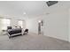 Bright main bedroom featuring neutral decor, carpet floors, and access to ensuite bathroom at 11205 Se 69Th Ter, Belleview, FL 34420