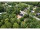New construction home with dark roof nestled in a wooded area, aerial view at 11506 Nw 20Th St, Ocala, FL 34482
