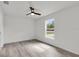 Light-filled bedroom with wood-look floors, a ceiling fan, and a large window offering a view at 11506 Nw 20Th St, Ocala, FL 34482