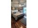 A bright bedroom featuring a patterned bedspread, hardwood floors, and a window with natural light at 12524 Sw 109Th Pl, Dunnellon, FL 34432