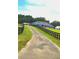 A long driveway leads to a single-story home with a black fenced in yard at 12524 Sw 109Th Pl, Dunnellon, FL 34432