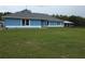 Attractive single-story home with blue exterior and white trim, set on a spacious lawn at 12524 Sw 109Th Pl, Dunnellon, FL 34432