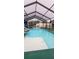 Swimming pool inside of enclosure, featuring waterfall and ample space for lounging at 12524 Sw 109Th Pl, Dunnellon, FL 34432