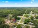 An aerial view of a neighborhood showcasing new construction, surrounded by lush greenery under a blue sky at 13803 Se 44Th Ave, Summerfield, FL 34491