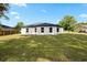 Exterior rear of home, featuring a spacious backyard with lush green grass at 13803 Se 44Th Ave, Summerfield, FL 34491