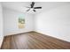 Bright bedroom featuring a ceiling fan and a view of the green outdoors through the window at 13803 Se 44Th Ave, Summerfield, FL 34491