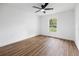 Bedroom with a ceiling fan and a view of the green outdoors through the window at 13803 Se 44Th Ave, Summerfield, FL 34491