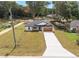 A exterior home view with a large driveway and attached two-car garage, sitting on a well-manicured lawn at 13803 Se 44Th Ave, Summerfield, FL 34491