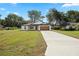 Charming single-story home with a well-manicured lawn and a long driveway at 13803 Se 44Th Ave, Summerfield, FL 34491
