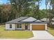 Well maintained front yard with luscious green grass, a new driveway, and a two-car garage at 13803 Se 44Th Ave, Summerfield, FL 34491