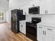 The modern kitchen is outfitted with sleek, black appliances and bright white cabinetry at 13803 Se 44Th Ave, Summerfield, FL 34491