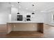 Kitchen island with breakfast bar, modern pendant lights, and black stainless appliances at 13803 Se 44Th Ave, Summerfield, FL 34491