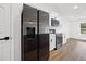 The modern kitchen has sleek, black appliances set against bright white cabinetry and countertops at 13803 Se 44Th Ave, Summerfield, FL 34491