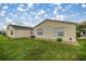 Well-maintained backyard with lush green grass, exterior of home, and small rock garden at 1405 Espinoza Ln, Lady Lake, FL 32159