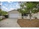 Inviting home with a well-manicured front yard, a picket fence, and an attached garage at 1405 Espinoza Ln, Lady Lake, FL 32159