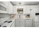 Bright kitchen features white cabinets, modern appliances, and a garden window at 1405 Espinoza Ln, Lady Lake, FL 32159