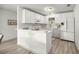 Modern white kitchen with ample cabinet space, stainless steel appliances, and a breakfast bar at 1405 Espinoza Ln, Lady Lake, FL 32159