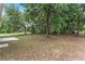 A view of the home's backyard featuring a concrete patio and a fire pit, set amongst mature trees at 14650 Sw 33Rd Ln, Ocala, FL 34481