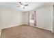 Bedroom with carpet flooring features a ceiling fan and a window with pink curtains at 14650 Sw 33Rd Ln, Ocala, FL 34481