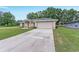 Single story home with a spacious driveway, attached garage and manicured lawn at 14650 Sw 33Rd Ln, Ocala, FL 34481