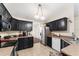 Well-lit kitchen featuring dark cabinets, stainless steel appliances, and tile flooring at 14650 Sw 33Rd Ln, Ocala, FL 34481