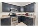 Well-equipped kitchen featuring stainless steel appliances, dark cabinetry, and plenty of counter space at 14650 Sw 33Rd Ln, Ocala, FL 34481
