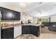Bright kitchen featuring dark cabinets, tile flooring, and an island overlooking the living area at 14650 Sw 33Rd Ln, Ocala, FL 34481