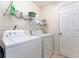 Laundry room with a washer and dryer, storage shelves, and a door at 14650 Sw 33Rd Ln, Ocala, FL 34481