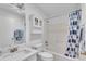 Clean bathroom with a tub, shower, and decorative blue floral curtain at 1819 Captiva Ct, The Villages, FL 32162