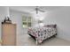 Bright bedroom with a floral comforter, tiled floors, and a ceiling fan at 1819 Captiva Ct, The Villages, FL 32162