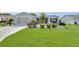 Charming single-story home featuring a manicured lawn, beautiful landscaping, and an attached garage at 1819 Captiva Ct, The Villages, FL 32162