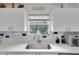 Beautiful kitchen features white cabinets, a large window, and modern appliances at 1819 Captiva Ct, The Villages, FL 32162