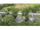 Aerial view of a single-story home surrounded by lush greenery and a peaceful pond, set back from the main road at 1831 Sw 5Th Ave, Ocala, FL 34471