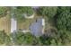 Birds-eye view shows the roof of the home, the driveway, the outdoor patio, and the surrounding trees and yard at 1831 Sw 5Th Ave, Ocala, FL 34471
