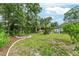 Expansive backyard featuring lush greenery, landscaping, and mature trees, offering a serene outdoor retreat at 19115 Sw 98Th Loop, Dunnellon, FL 34432
