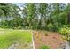Lush backyard featuring verdant foliage and garden beds, creating a serene oasis at 19115 Sw 98Th Loop, Dunnellon, FL 34432
