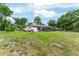 Wide backyard featuring an enclosed patio, lush grass, and a view of the home's exterior at 19115 Sw 98Th Loop, Dunnellon, FL 34432