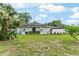 Grassy backyard with a home featuring a metal roof, and some lush tropical foliage at 19115 Sw 98Th Loop, Dunnellon, FL 34432