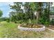 Well-manicured backyard garden with lush greenery and decorative stone border at 19115 Sw 98Th Loop, Dunnellon, FL 34432