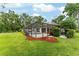 View of a lush backyard with a screened-in pool area, surrounded by trees and a well-maintained lawn at 19115 Sw 98Th Loop, Dunnellon, FL 34432