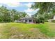 Lush backyard with screened-in pool area, trees, and a well-maintained lawn, perfect for outdoor enjoyment at 19115 Sw 98Th Loop, Dunnellon, FL 34432