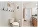 Bathroom featuring a toilet, shower/tub combo, and sink with a door to the exterior at 19115 Sw 98Th Loop, Dunnellon, FL 34432